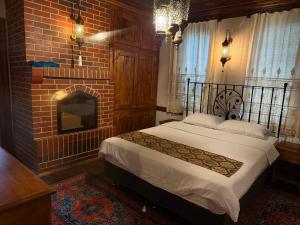 a bedroom with a bed and a brick fireplace at Valide Sultan Konağı TARAKLI in Taraklı