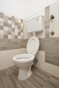 a bathroom with a white toilet in a room at New Spacious 2BHK apartments in Tirupati Near Railway Station with fully equipped kitchen, AC bedrooms, Washing Machine, 24 hours water, caretaker service, and ample space for car parking & ideal for families and pilgrims in Tirupati
