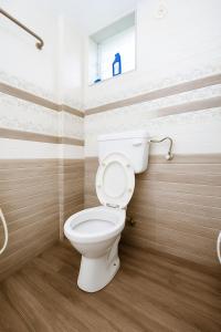 a bathroom with a white toilet in a room at New Spacious 2BHK apartments in Tirupati Near Railway Station with fully equipped kitchen, AC bedrooms, Washing Machine, 24 hours water, caretaker service, and ample space for car parking & ideal for families and pilgrims in Tirupati