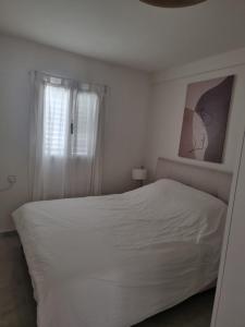 海法דירת נופש על הים בחיפה的一间带床和窗户的白色卧室