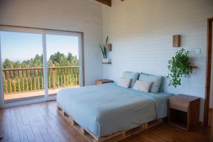 a bedroom with a bed and a large window at Casamar Retreat Buchupureo in Buchupureo