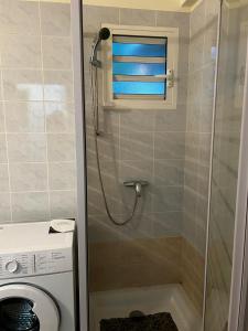 a shower stall in a bathroom with a window at Accommodation close to beach in Pointe-Noire
