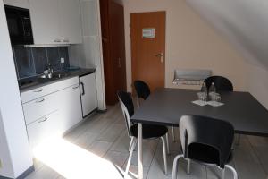 a kitchen with a black table and black chairs at Hotel Urs und Viktor in Bettlach