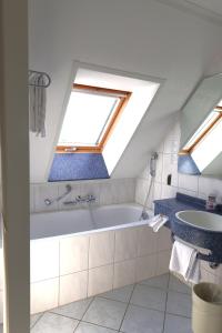 a bathroom with a bath tub and a sink at Hotel Urs und Viktor in Bettlach