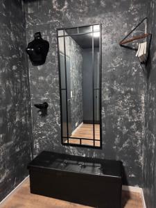 a black bathroom with a mirror and a black tub at Loft apartment in Kouvola +8 photos