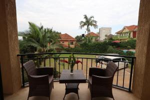 einen Balkon mit einem Tisch und Stühlen sowie Aussicht in der Unterkunft Bon Bini Residence in Kampala