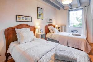 Un dormitorio con dos camas y una ventana. en Le Gîte du Château Fouquet - Piscine privée, en Brézé