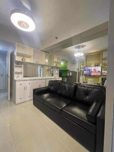 マニラにあるSea Residences Etherealのリビングルーム(黒い革張りのソファ付)