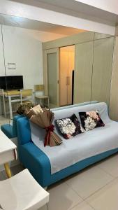 マニラにあるSea Residences Etherealのリビングルーム(青いソファ、枕付)
