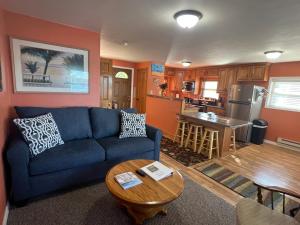 a living room with a blue couch and a kitchen at Lakin' It Easy in Middlebury