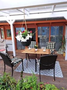 eine Terrasse mit einem Holztisch mit Stühlen und Blumen in der Unterkunft Ferienwohnung, ruhig im Grünen in Osterrönfeld