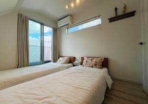 two beds in a room with a large window at 大阪第一站 in Osaka