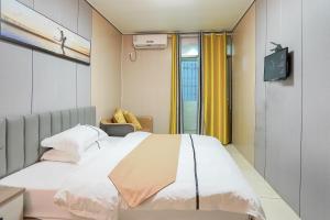 Una habitación de hospital con una cama y un televisor. en UPTO Hotel, en Xiamen
