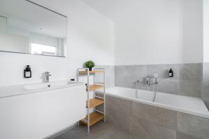 a bathroom with a white tub and a sink at homy City Diamant - Penthouse in Feldkirch, Grenznähe und doch Zentral in Feldkirch +15 photos