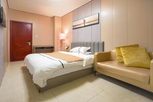 un dormitorio con una cama y un sofá en UPTO Hotel, en Xiamen