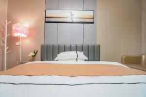 Un dormitorio con una cama grande y un televisor encima. en UPTO Hotel, en Xiamen