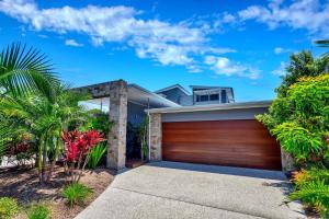 a house with a wooden garage door at Stonecutters 2 in Byron Bay