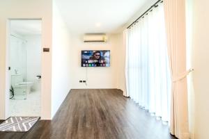 a hallway with a bathroom with a toilet and a television at Stylish 3 Bedroom Villa with Garden, Chalong - by PoshSaga in Chalong 