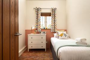 une chambre avec deux lits et une commode et une fenêtre dans l'établissement Coot, à Waterden 6 autres photos