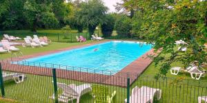 a pool with chairs and a person swimming in it at Unique et Insolite Bus Iliade in Bourg