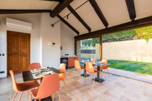 cocina y comedor con mesas y sillas naranjas en Vittoria Suite, en Bra