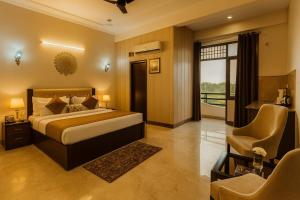 a bedroom with a bed and a desk and a chair at The Four Season Resort, Vrindavan- A Hidden Gem Nested In Nature's Lap # By Elegance Group # in Vrindāvan +48 photos