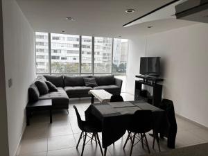 een woonkamer met een bank en een tafel bij torre renoir 96, depto 306 in Mexico-Stad