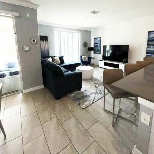 un salon avec un canapé et une table dans l'établissement Gorgeous Condo Close to Disney w Private Pool BBQ - Themed Bedrooms Walk To Clubhouse, à Kissimmee