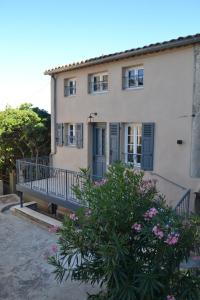 una casa con balcón y flores delante de ella en Appartement en duplex vue sur mer, en Grimaud