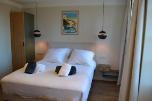 Un dormitorio con una gran cama blanca con dos almohadas. en Appartement en duplex vue sur mer, en Grimaud