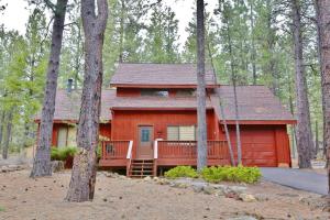 a red cabin in the middle of the forest at 8 Leisure in Sunriver