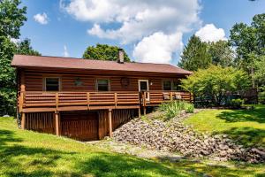 a log cabin with a large porch in a yard at Almost Heaven Family Vacation Cabin - Three Bedroom Cabin in Spearsville