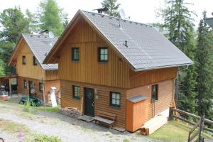 a large wooden house with a gambrel roof at Turracher Berghütte in Turracher Hohe