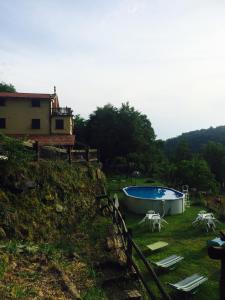 a swimming pool in a yard next to a house at Agriturismo LA TAVERNA DEL NONNO in Borzonasca