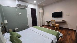 a bedroom with a bed and a desk with a television at Subah E Banaras in Varanasi
