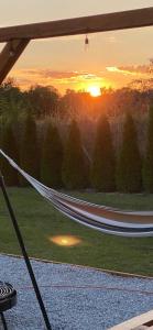 a hammock with the sunset in the background at Domek pod Sosnową Górą in Żelazno