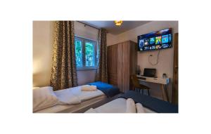 a living room with a couch and a table and a television at Lovely Home In Sinj in Rožani