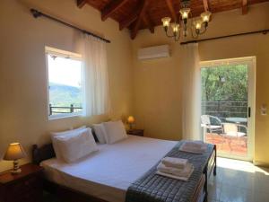 a bedroom with a bed and a large window at Villa Aliona in Mavráta +20 photos