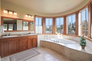 a large bathroom with a tub and two sinks and windows at Drake Park Villa in Bend +65 photos
