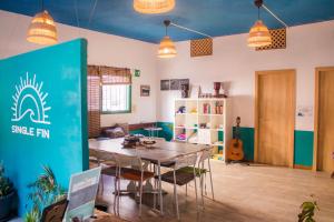 a dining room with a table and chairs in a room at Single Fin Surf Hostel in Arona
