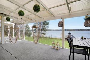 un porche grillagé avec des hamacs et une vue sur l'eau dans l'établissement Luxury Villa Riverside, Private Sauna & Wifi, à Rovaniemi