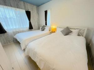 two white beds in a room with a window at Grandioso OKINAWA VILLA ONNA 5A - Vacation STAY 97835 in Meta