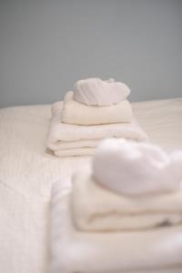 a stack of white towels on a bed at 2 bedroom suite Walk to SkyTrain, Grocery, Macdonald & more in Vancouver +27 photos