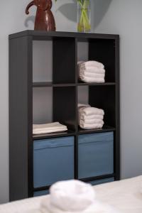 a black book shelf with blue drawers and towels at 2 bedroom suite Walk to SkyTrain, Grocery, Macdonald & more in Vancouver