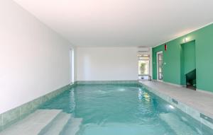 an indoor swimming pool with green and white walls at Nice Home In Vir With Sauna in Kaštelina +17 photos