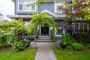a house with a pathway leading to the front door at 2 bedroom suite Walk to SkyTrain, Grocery, Macdonald & more in Vancouver