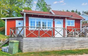 una casa rossa e bianca con una recinzione in legno di Lovely Home In Gränna With Sauna a Bjällebäck