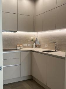 a kitchen with white cabinets and a sink at Comfortable apartment - Monza park with garage in Biassono