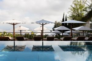 巴塞罗那METT Barcelona GL - A Leading Hotel of the World的一个带遮阳伞和桌椅的游泳池
