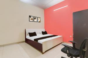 Un dormitorio con una cama con una pared roja. en HOTEL O S.R GRAND INN, en Sītāpur